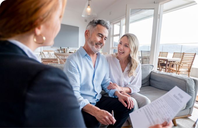 A man and woman engage in conversation with a real estate agent regarding real estate opportunities.